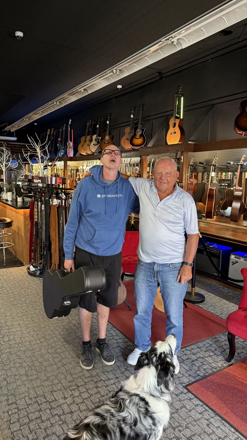 Cory sharing a laugh with a friend in a guitar shop